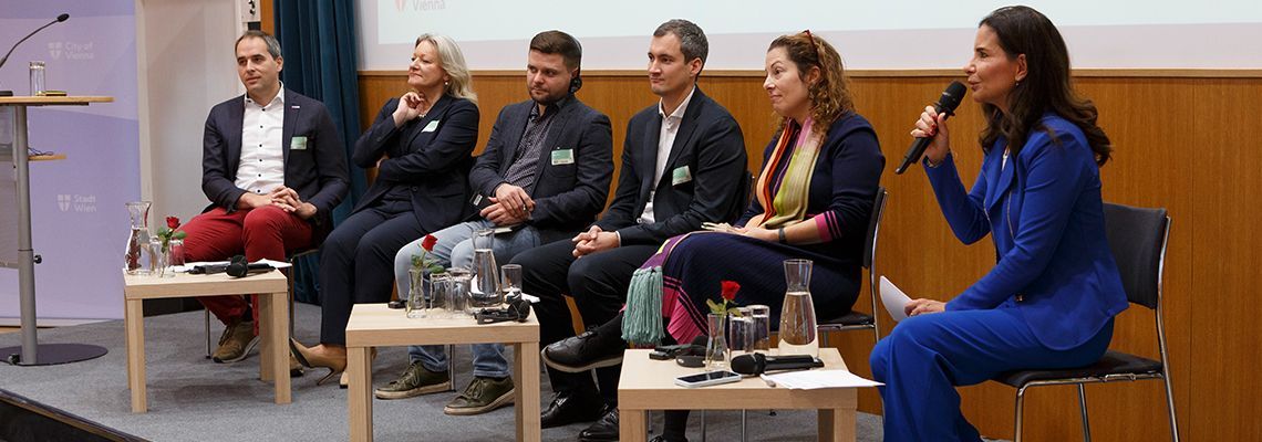 Sechs Personen sitzend bei einer Podiumsdiskussion