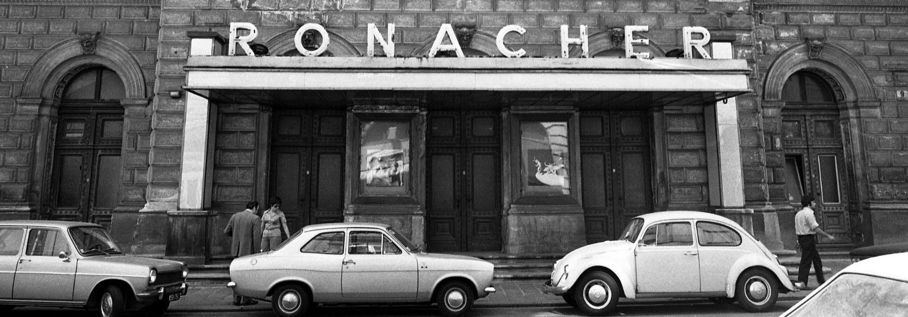 Historische Ansicht Ronacher mit drei Autos im Vordergrund, alles ist in schwarz-weiß gehalten