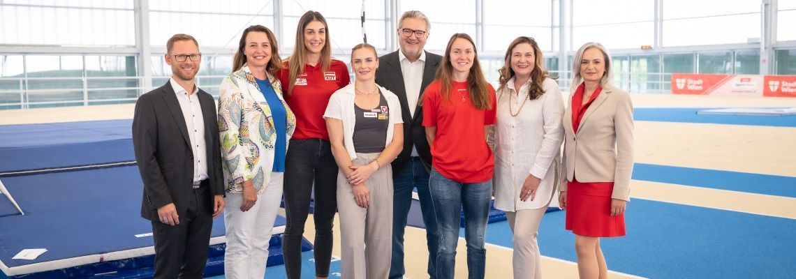 Acht Personen in einer Sporthalle