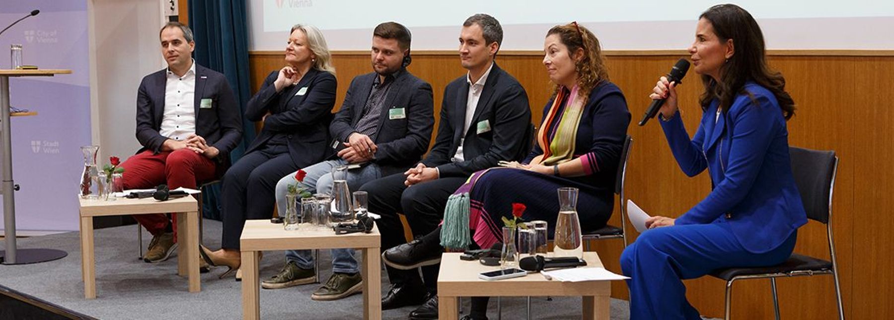 Sechs Personen sitzend bei einer Podiumsdiskussion