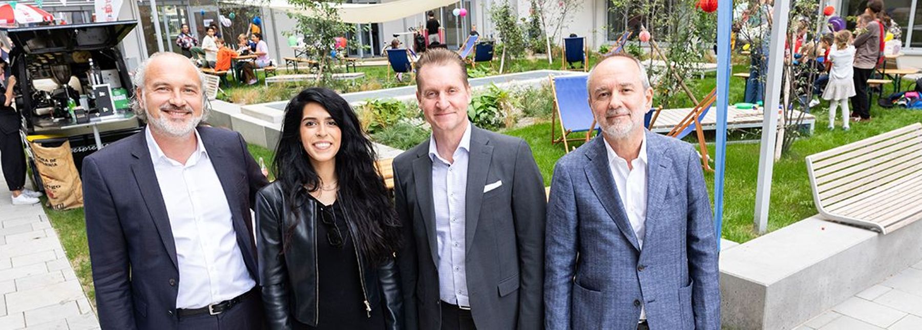 Vier Personen vor einer Grünfläche