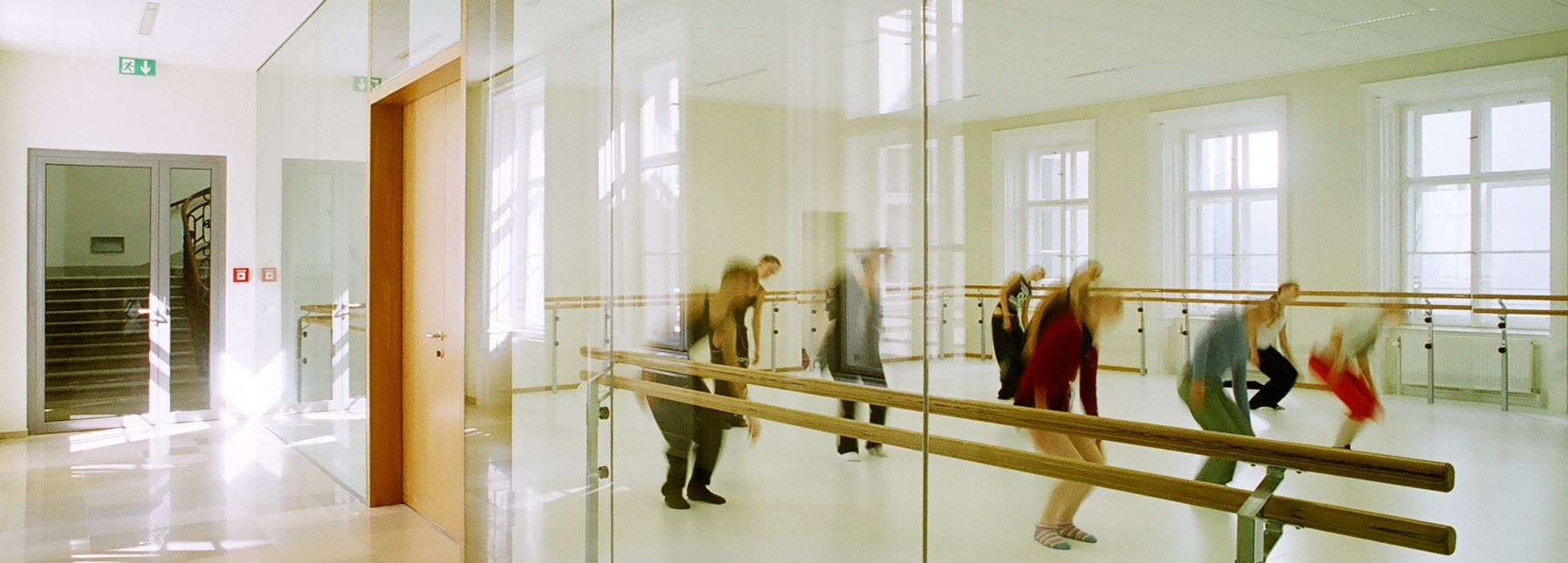 Zu sehen sind neun Studierende der MUK in einem Tanzraum beim Training.