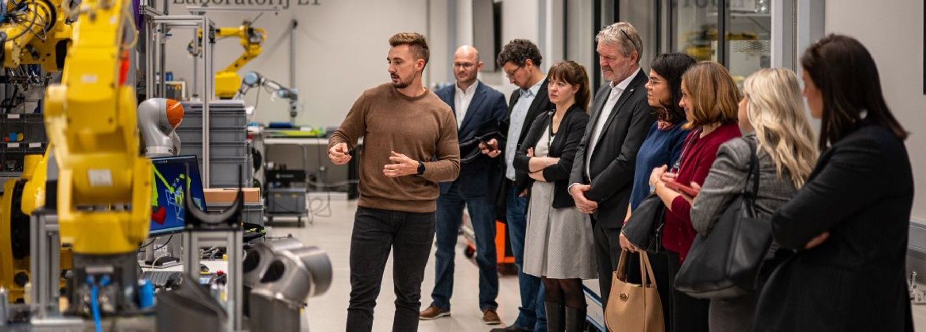 Acht Personen vor einer Maschine