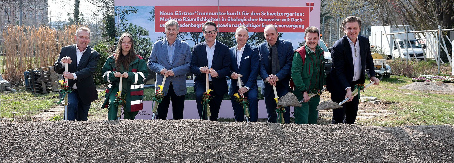 Menschen mit Schaufeln vor Sandhaufen