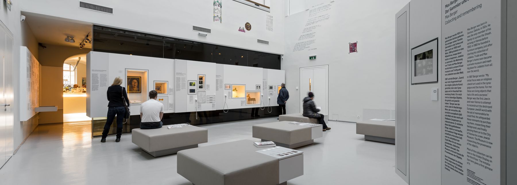 Zu sehen sind vier Personen, die sich Objekte der Dauerausstellung "Unsere Stadt" ansehen.