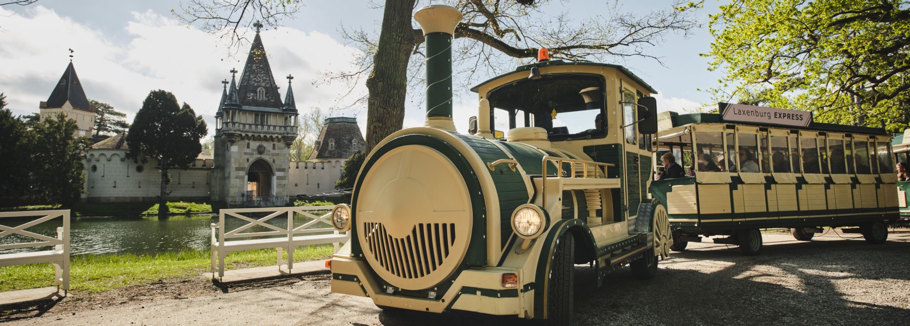 Ein Bummelzug im Schlosspark Laxenburg, im Hintergrund ist die Franzensburg zu sehen.