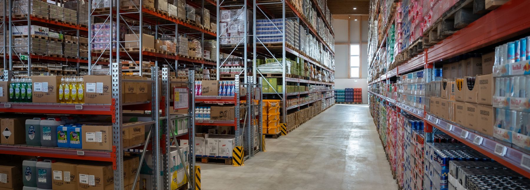 Orient Abholmarkt im Großmarkt Wien mit Gängen, in denen viele Produkte gestapelt und Kisten aufgereiht sind.