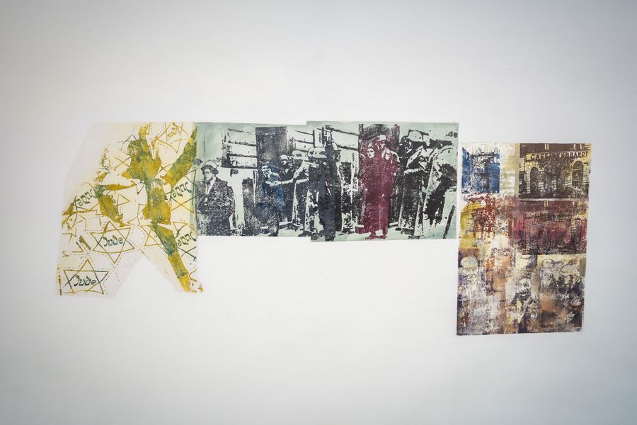 Eines der Kunstwerke von Nancy Spero in Nahaufnahme. Gelbe Judensterne und eine Collage aus verschiedenen Figuren und Gebäuden.