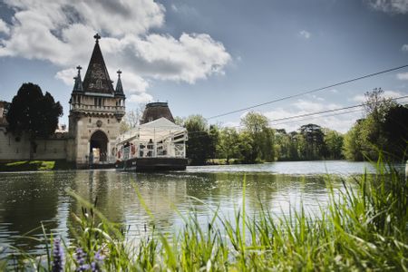 Eine Fähre fährt zur Franzensburg auf dem See.