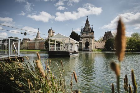 Eine Fähre fährt zur Franzensburg auf dem See.