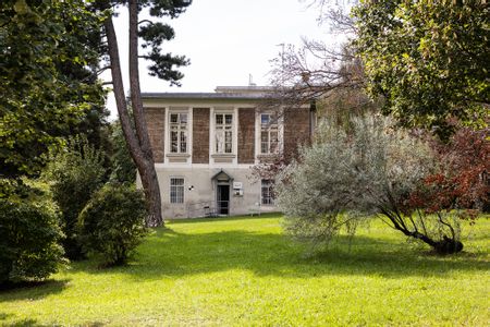 Backsteingebäude am Otto-Wagner-Areal, umgeben von Wiese und Bäumen.