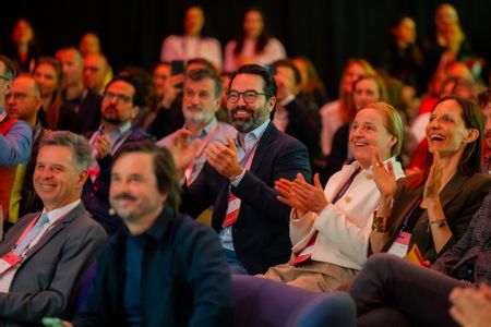 Eine Gruppe applaudierender und lachender Menschen