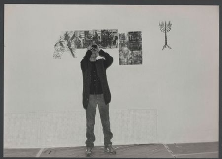 Eine schwarz-weiß Aufnahme von Nancy Spero im Jüdischen Museum Wien mit einem Feldstecher blickt sie an die Decke