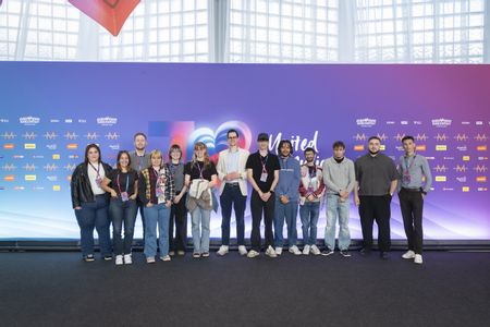 eine Gruppe junger Menschen vor einer ESC-Kulisse