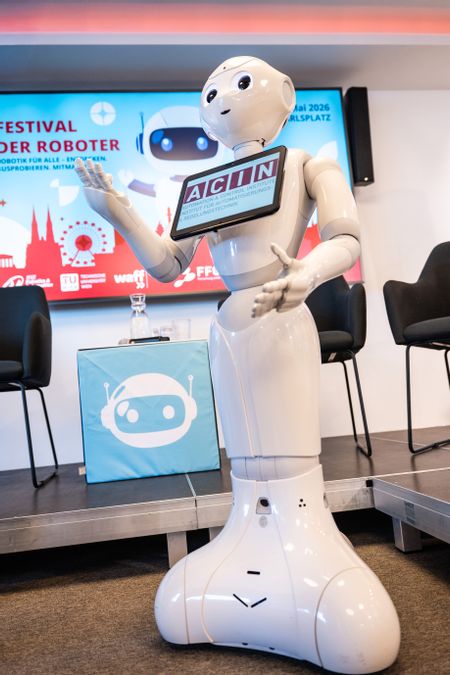 Ein weißer Roboter mit einem Tablet vor der Brust