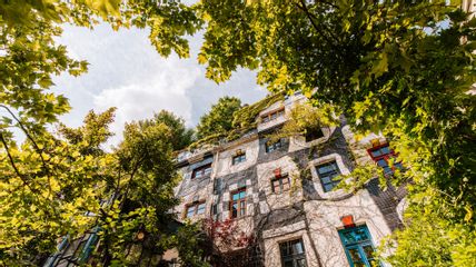 Die Fassade des KunstHausWien: Ein buntes Haus, umgeben von Bäumen