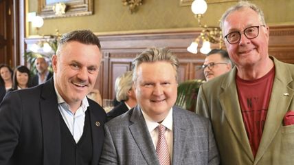 Gruppenbild aus drei Herren bei einer Festgesellschaft